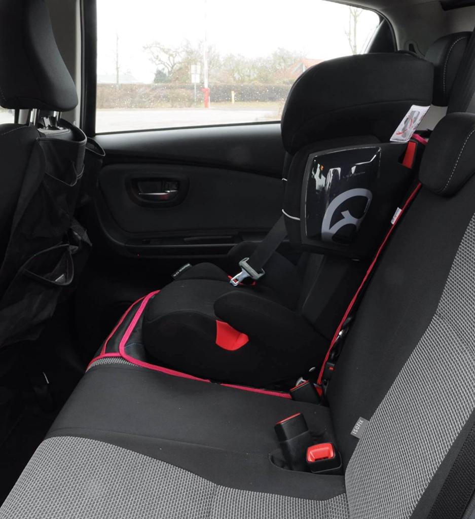 Wumbi Sitzschutz in pink unter einem Kindersitz
